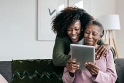 Mother and daughter looking at options on a tablet computer.